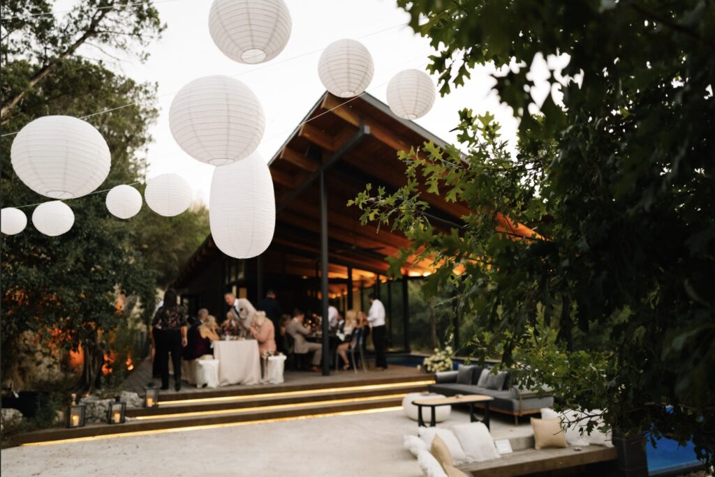 Small backyard wedding with white lanterns and people
