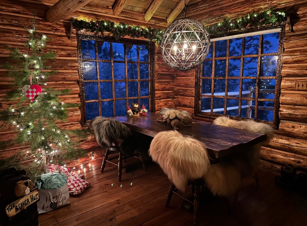 Log cabin with christmas tree, garlands and table for Christmas gender reveal party