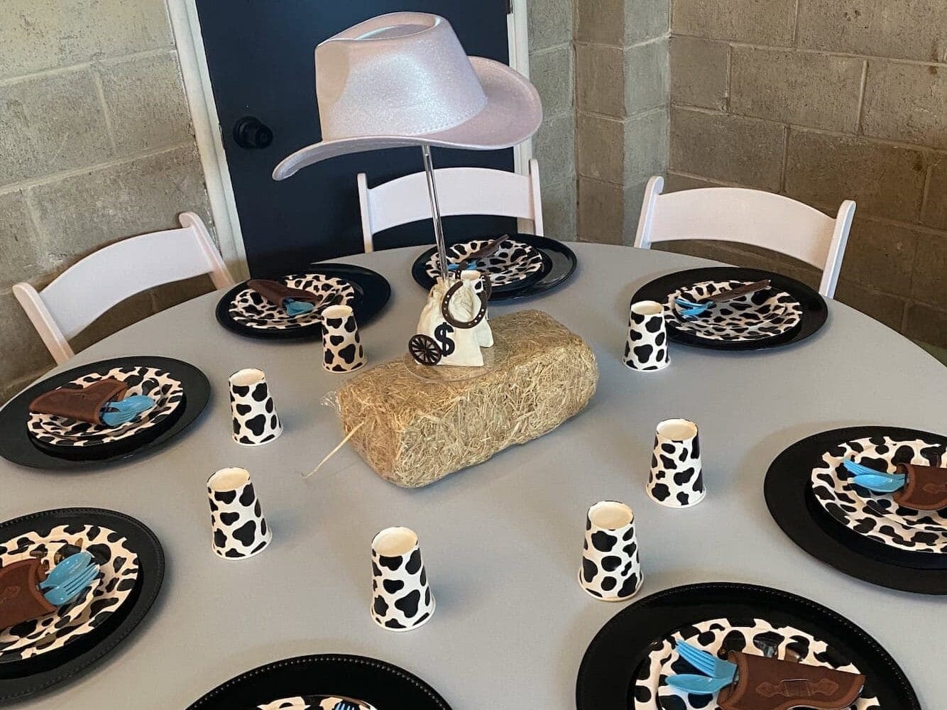 Cowboy theme plates, hat, cups on party table