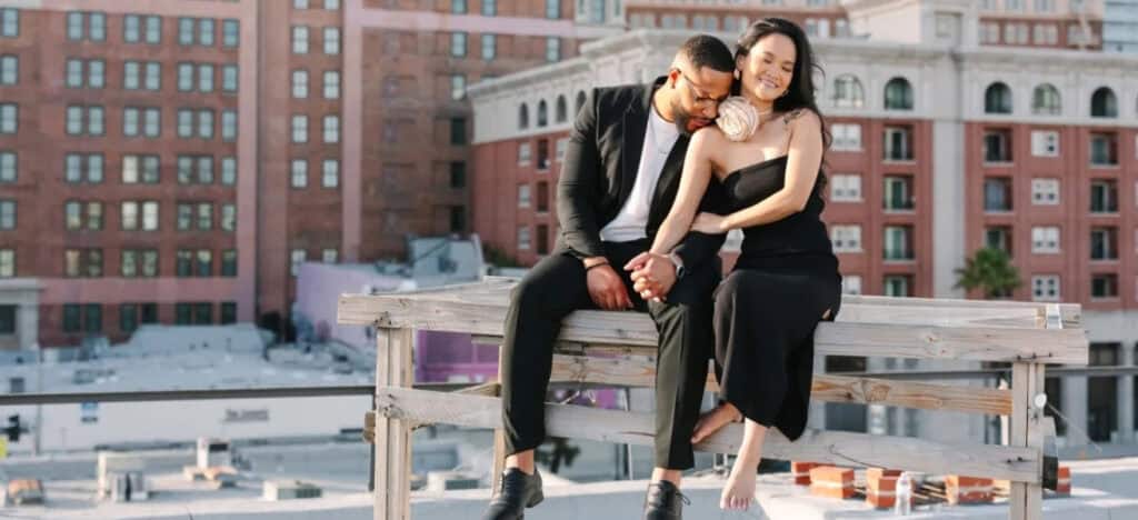 Couple on rooftop holding hands.