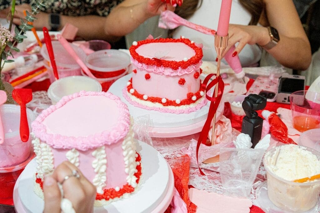 Pink and red frosting cake decorating for Galentine's theme
