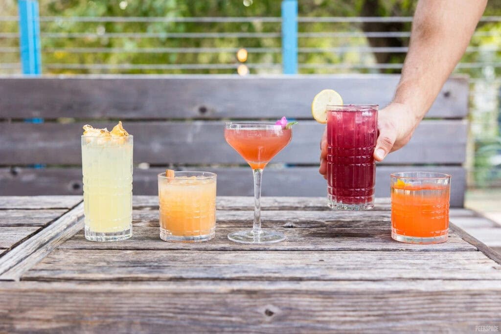 Brightly colored drinks atop a wooden bar