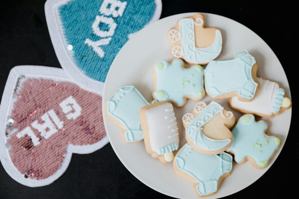 Gender reveal cookies sit on a plate at a baby event