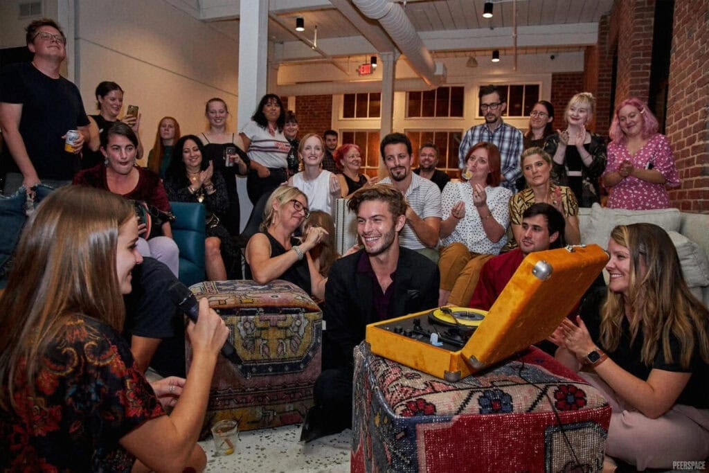 A group gathers around a record player at a venue in Atlanta