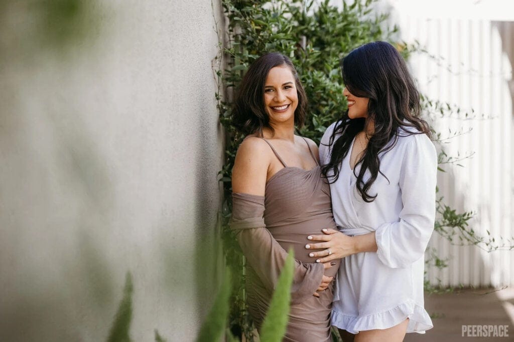 A mom to be and a friend pose at a baby event