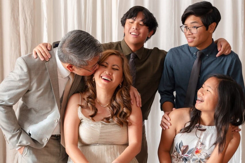 Mom birthday ideas photoshoot with family of 5 in front of backdrop