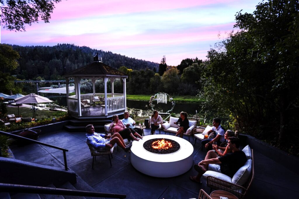 people gathered around a firepit lakeside