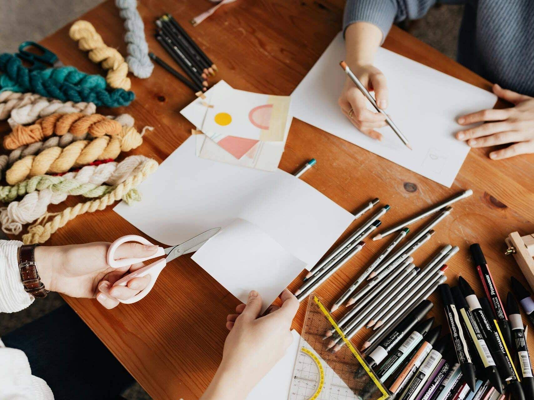 Indoor birthday party idea with two friends doing fiber and drawing crafts at a table