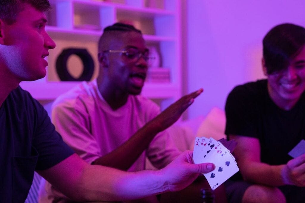 Three friends playing cards in a living room