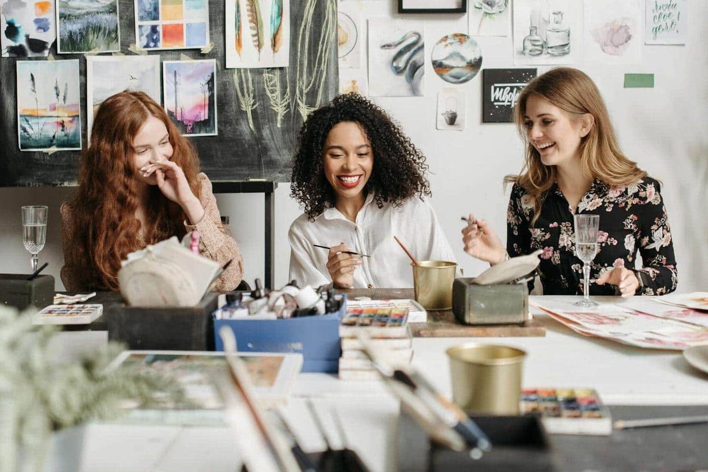 Three friends at Galentines party at home doing a painting craft