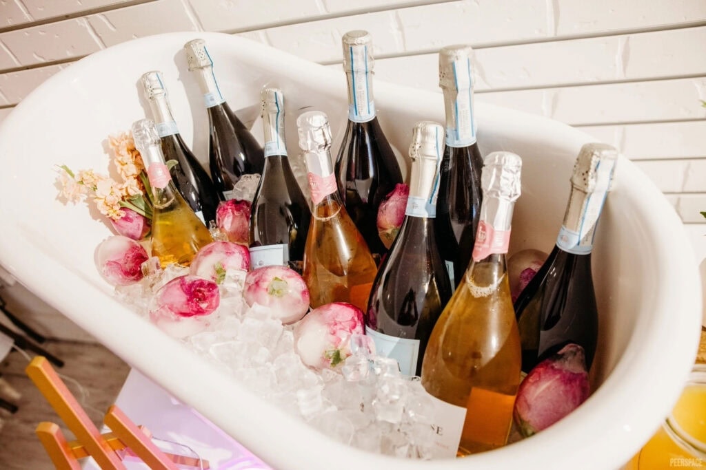 Bottles of champagne and Prosecco sit in a mini bathtub on ice